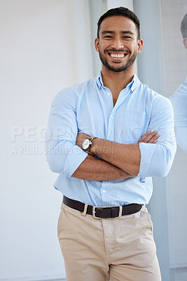 Buy stock photo Portrait of a confident young businessman standing with his arms crossed in an office