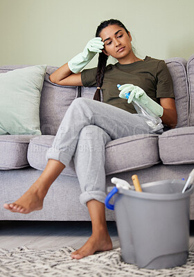 Buy stock photo Shot of a young woman looking tired while cleaning at home