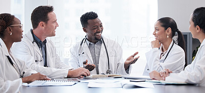 Buy stock photo Cropped shot of a group of young doctors having a meeting around a table in the hospital boardroom