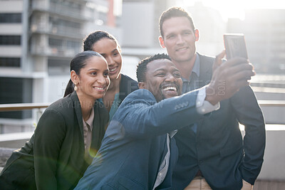 Buy stock photo Shot of a group of businesspeople taking a selfie against a city background
