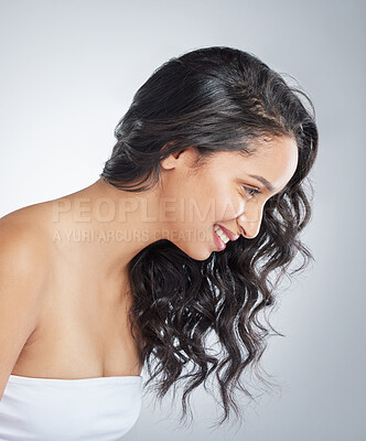 Buy stock photo Shot of an attractive young woman standing alone and posing with curly hair in the studio