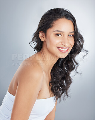 Buy stock photo Shot of an attractive young woman standing alone and posing with curly hair in the studio