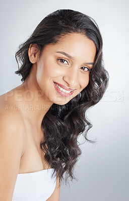 Buy stock photo Smile, portrait and girl in studio for curly hair treatment, wellness and shampoo, shine or cosmetics on grey background. Happy, face and model with beach waves, haircare and texture styling results
