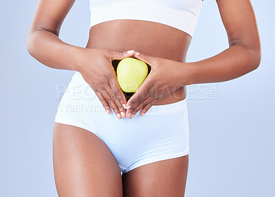 Buy stock photo Shot of an unrecognisable woman holding an apple over her stomach