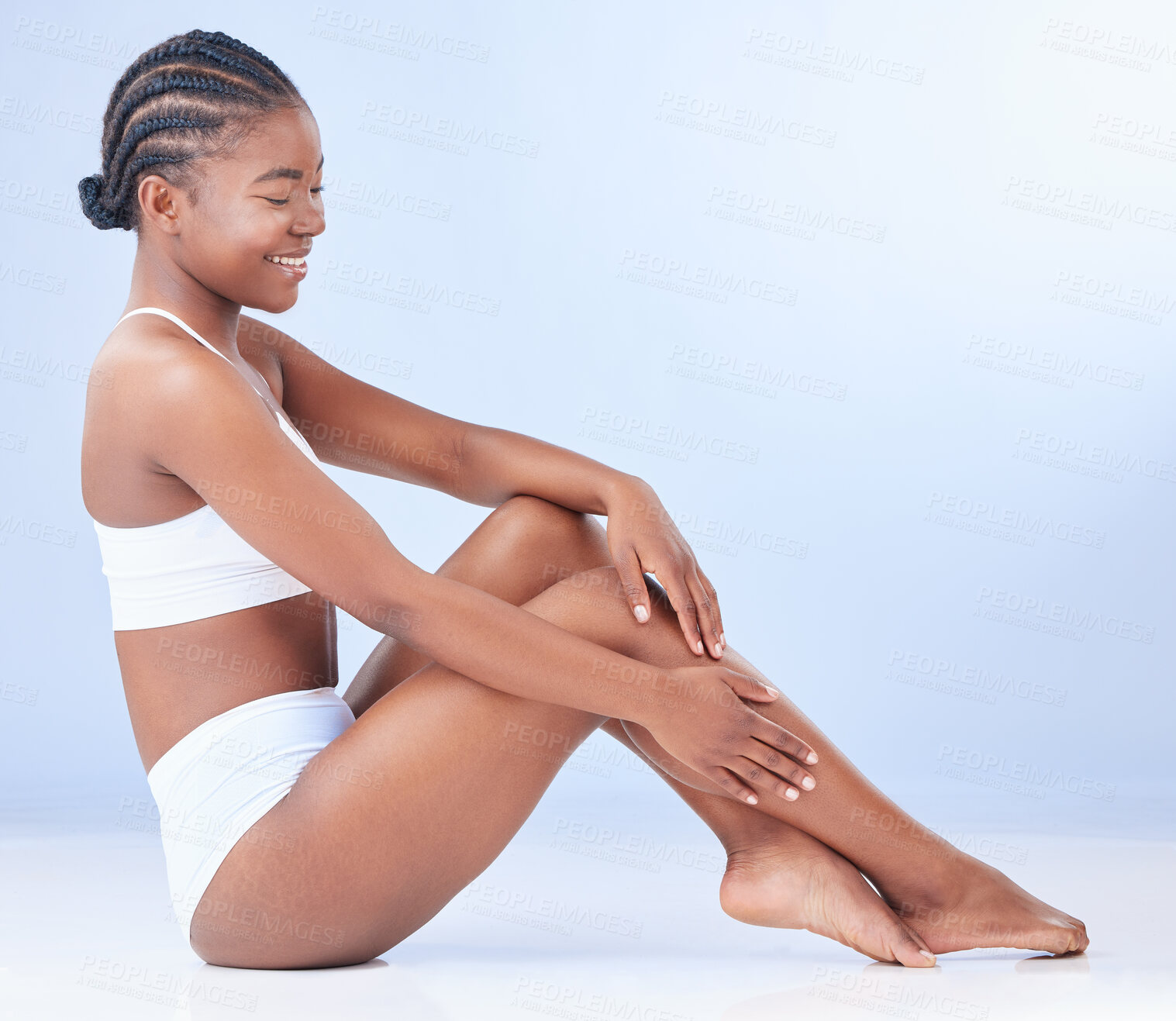 Buy stock photo Black woman, floor and legs for skincare in studio with mockup space, healthy body and glow by blue background. Girl, person and model with waxing, hair removal and happy for cosmetic transformation