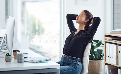 Buy stock photo Shot of a young businesswoman sitting with her hands behind her head at a desk in an office