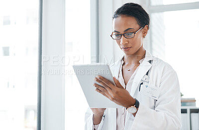 Buy stock photo Shot of a young doctor using her digital tablet at work