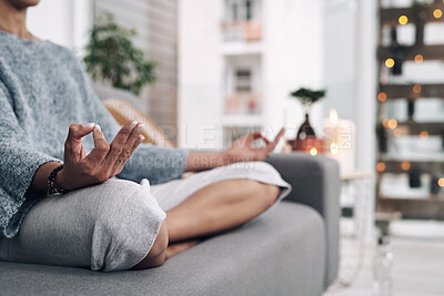 Buy stock photo Shot of an unrecognizable woman meditating on a sofa at home