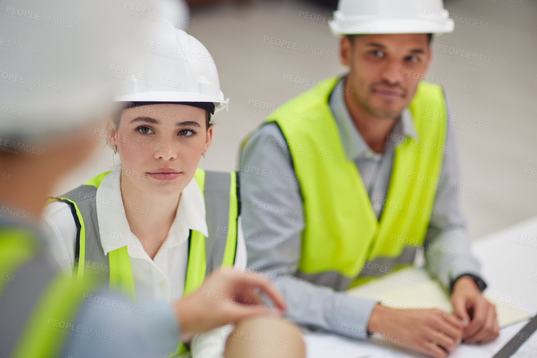 Buy stock photo High angle shot of two young construction workers listening to a colleague during a meeting in the boardroom