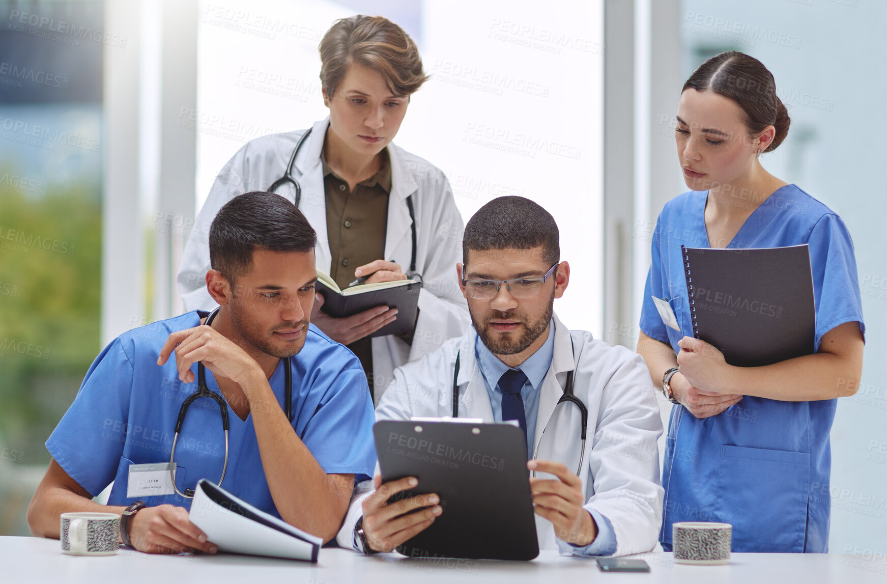 Buy stock photo Shot of a group of medical practitioners working together in a hospital boardroom