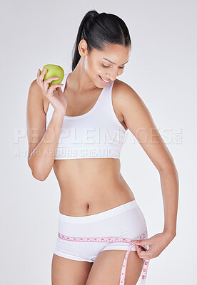 Buy stock photo Woman, measuring tape and apple in studio for detox, tracking progress and white background. Female person, weight loss and results of liposuction or nutrition, cosmetic change and diet for health