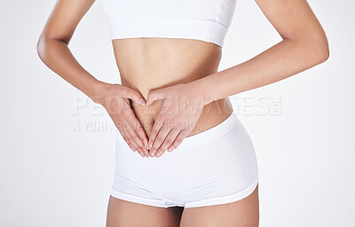 Buy stock photo Woman, stomach and hands for heart in studio, gut health and digestion on white background. Female person, emoji and weight loss or love results of detox, self care and abdomen or colon wellness