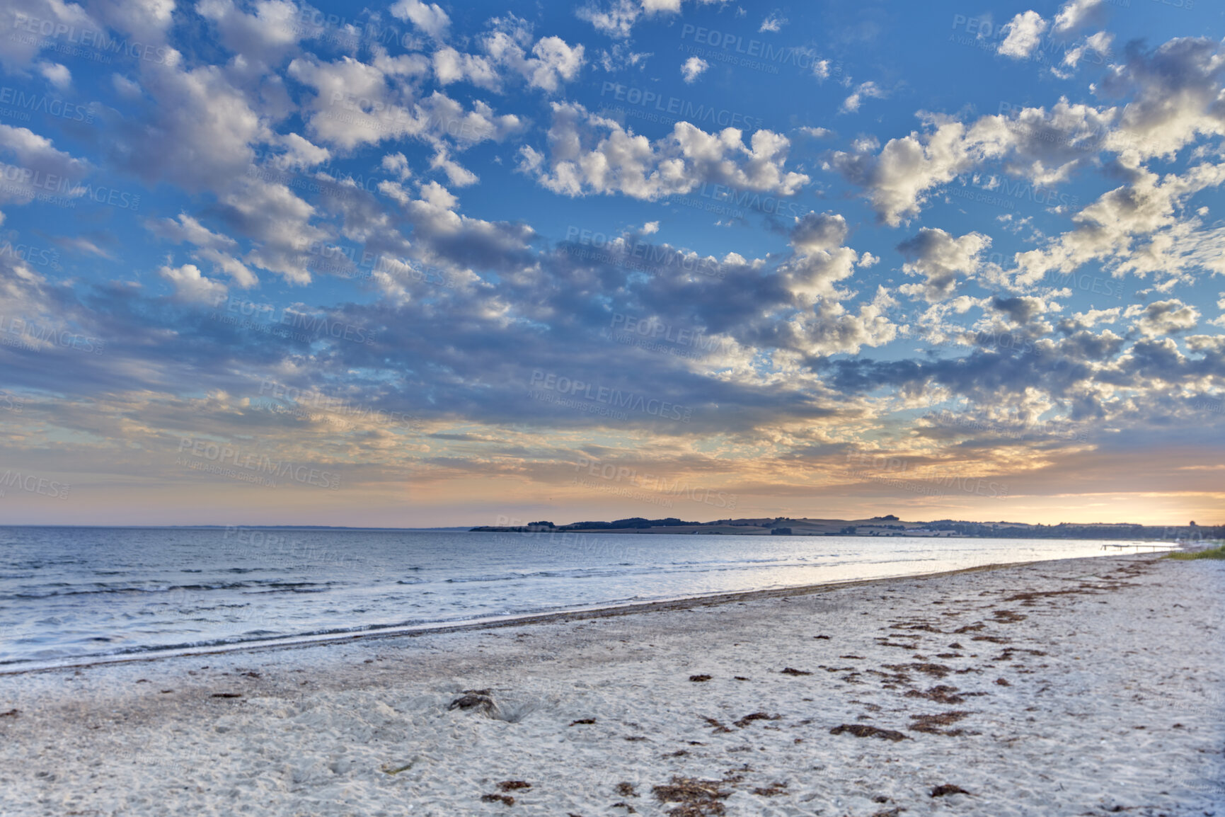 Buy stock photo Seascape view of nature on the coast of a beach, and ocean water on a sunny summer day. Beautiful scenery of a sea shore filled with sand and a cloudy blue sky over the horizon with tide and current