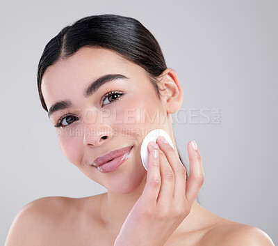 Buy stock photo Studio portrait of an attractive young woman exfoliating her face against a grey background