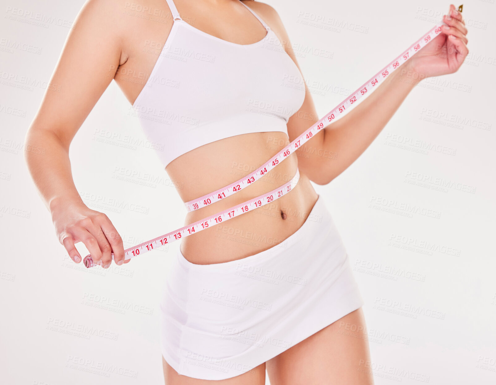 Buy stock photo Woman, hand and body with measuring tape in studio for weight loss, progress or results of diet. Female person, underwear and healthy with stomach for self care, wellness or waist on white background