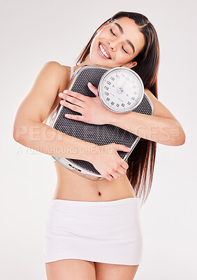 Buy stock photo Studio shot of an attractive young woman posing with a weightscale against a grey background