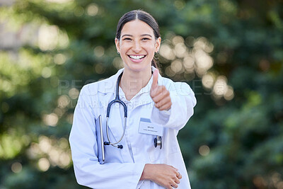 Buy stock photo Shot of a young female doctor showing a thumbs up in nature