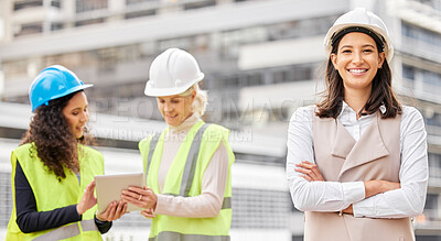 Buy stock photo Cropped portrait of an attractive young female engineer standing with her arms folded with her colleagues in the background on a construction site