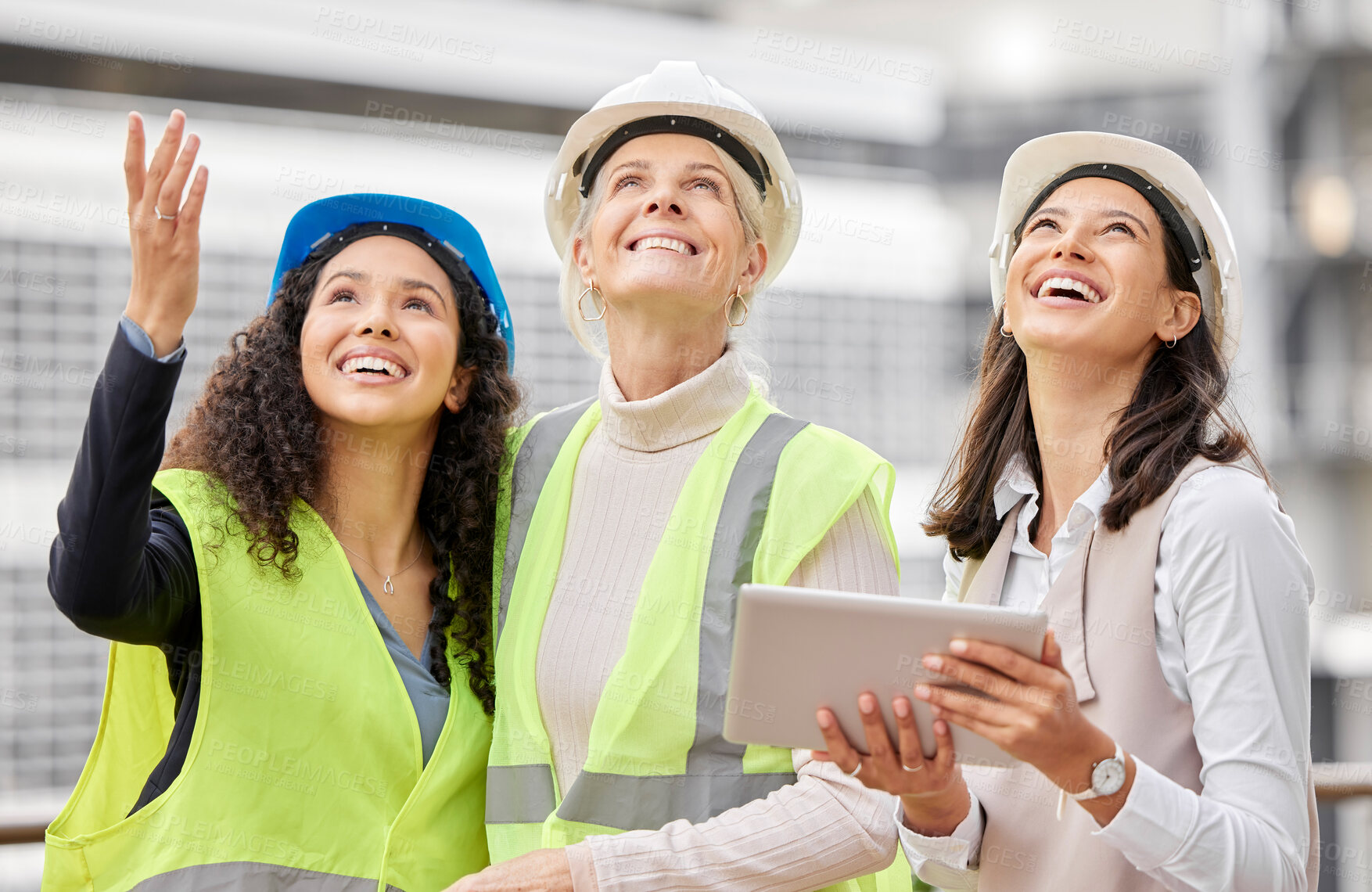 Buy stock photo Cropped shot of three attractive female engineers using a tablet while working on a construction site