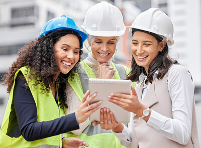 Buy stock photo Cropped shot of three attractive female engineers using a tablet while working on a construction site