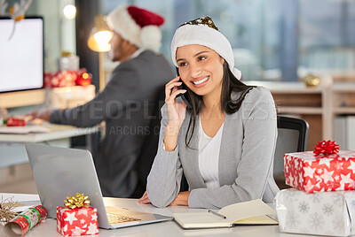 Buy stock photo Shot of a young businesswoman using a laptop and smartphone in a modern office at Christmas