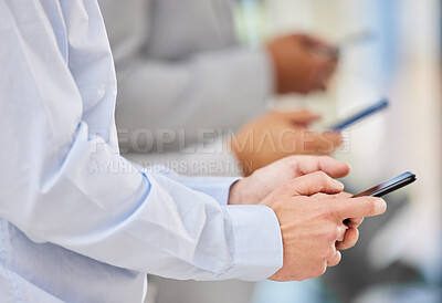 Buy stock photo Shot of unrecognizable businessmen using mobile devices in an office