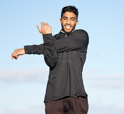 Buy stock photo Shot of a young man stretching his arms before his morning run