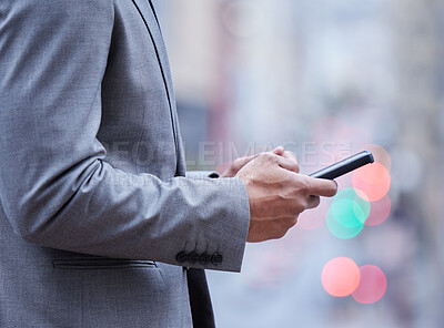 Buy stock photo Cropped shot of an unrecognisable businessman standing alone and using his cellphone