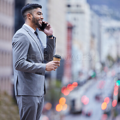 Buy stock photo Shot of a handsome young businessman standing alone and using his cellphone while enjoying a cup of coffee