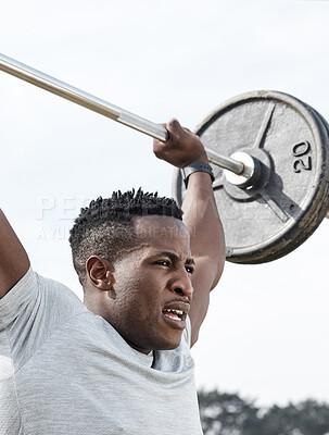 Buy stock photo Shot of a man using a barbell while exercising outdoors