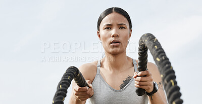 Buy stock photo Shot of an athletic young woman doing heavy rope training outside