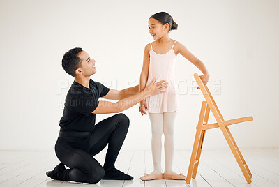 Buy stock photo Shot of a ballet teacher assisting a student with her position in a dance studio