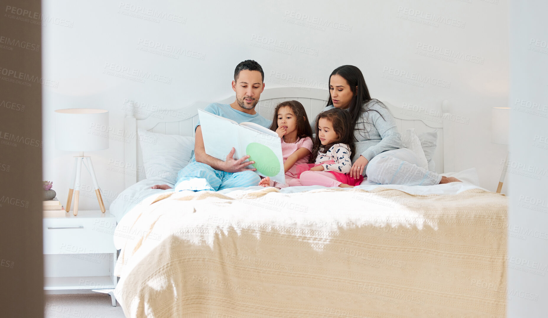 Buy stock photo Family, girls and people with storytelling on bed at home for fun, bonding and care with education. House, parents and kids with learning on book reading for knowledge, information and child growth