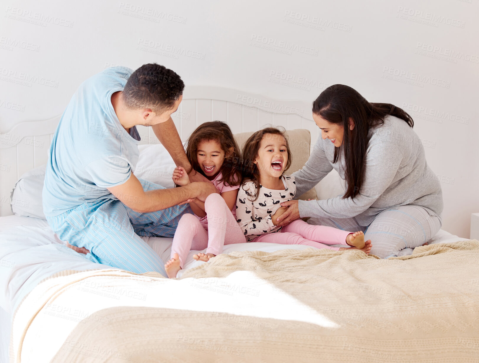 Buy stock photo Family, tickle and kids on bed for love, relationship development and happiness at home. Parents, children and laugh in bedroom for weekend games, entertainment and bonding in morning for wake up