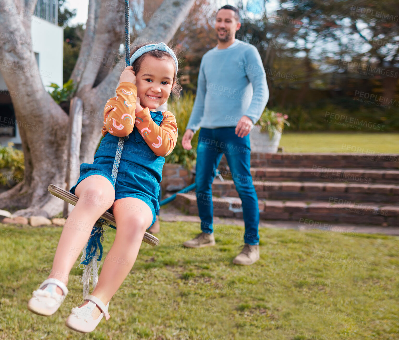 Buy stock photo Shot of a little girl swinging in a park