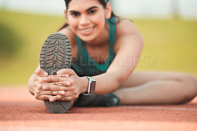 Buy stock photo Cropped portrait of an attractive young sportswoman stretching on a running track