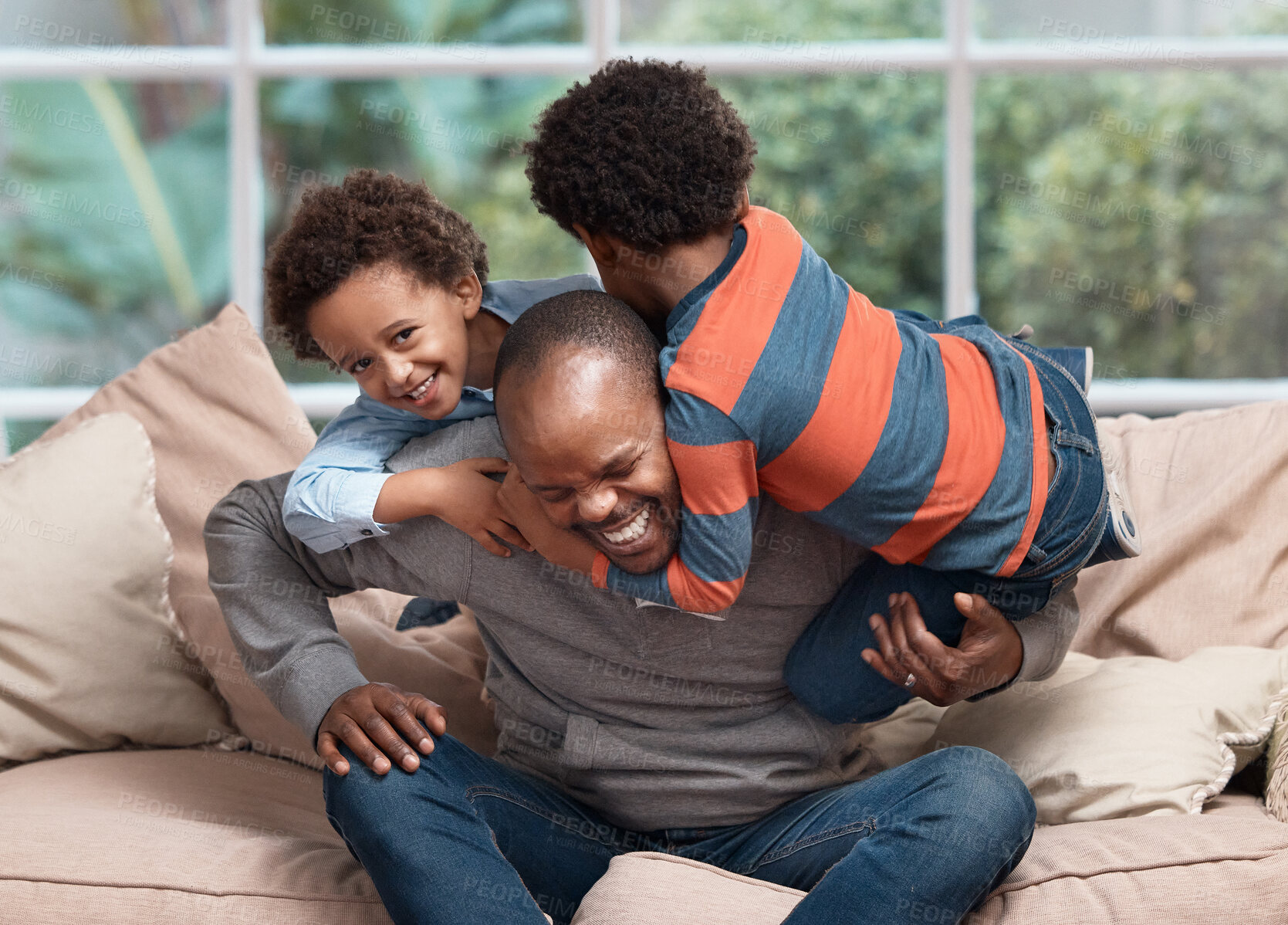 Buy stock photo Shot of a father playing with his two little sons on a sofa at home