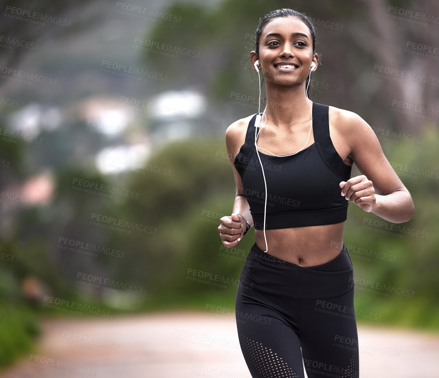 Buy stock photo Running in nature, woman with earphones and fitness, mockup space and smile on healthy workout on path. Exercise, health and wellness, happy girl runner on forest path with music and training mindset