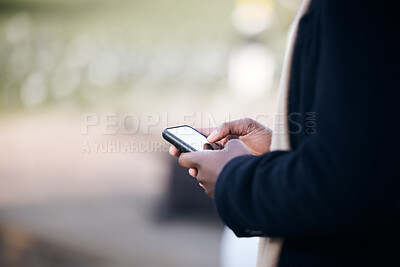 Buy stock photo Shot of a unrecognizable business man using his cellphone outside