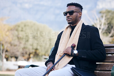 Buy stock photo Blind black man, park bench and outdoor with sunglasses, walking stick or relax by trees, peace or thinking. African guy, vintage fashion and young person with disability, glasses or travel in nature