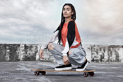 Buy stock photo Skateboard, clouds and portrait of woman skater with fashion for skating with casual, trendy and cool outfit. Serious, street and female person with confidence for hobby and style in California.