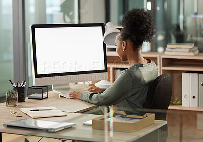 Buy stock photo Rearview shot of an unrecognizable young businesswoman working at her desk in the office