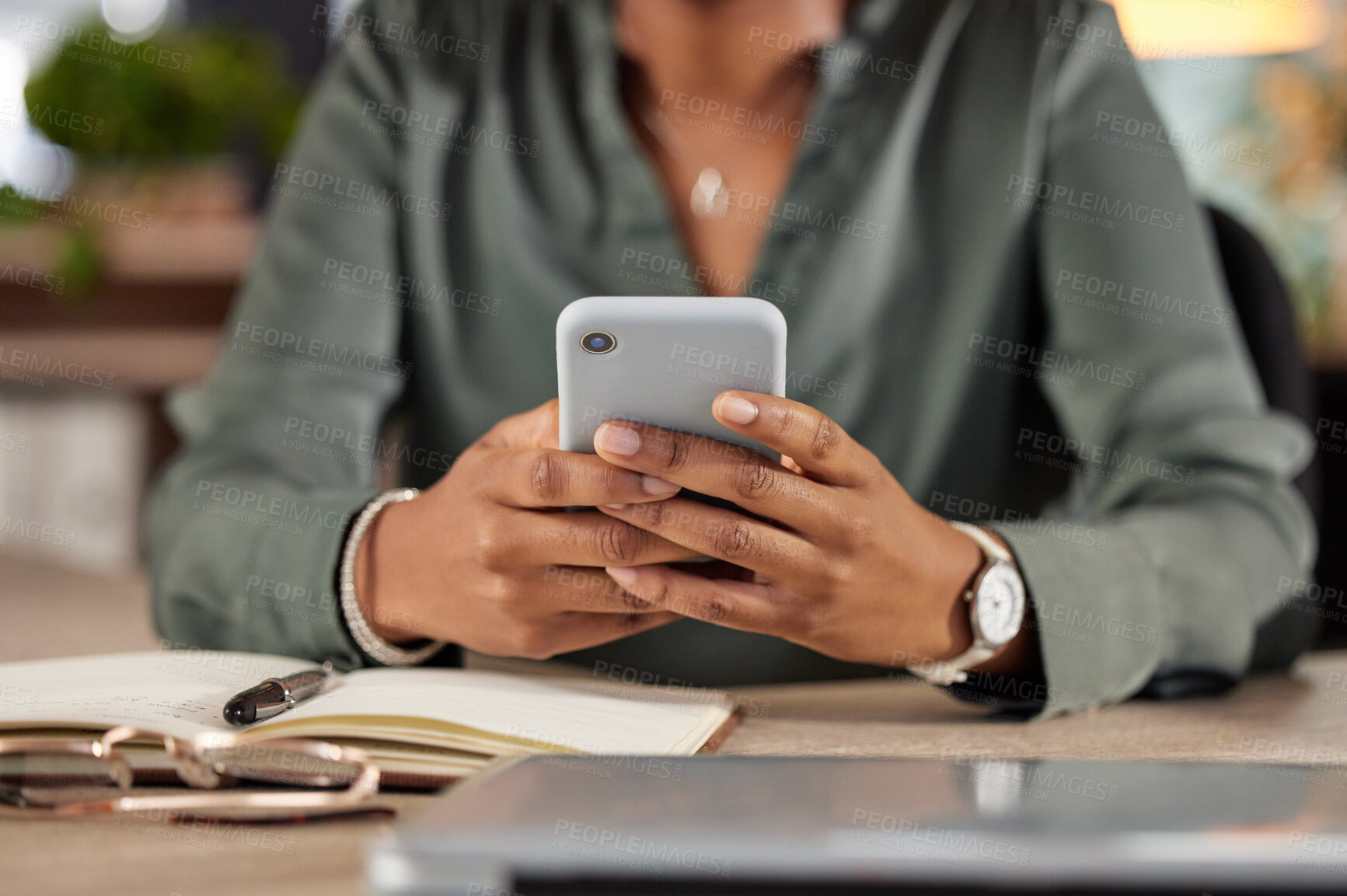 Buy stock photo Cropped shot of an unrecognizable businesswoman sending a text while sitting at her desk in the office