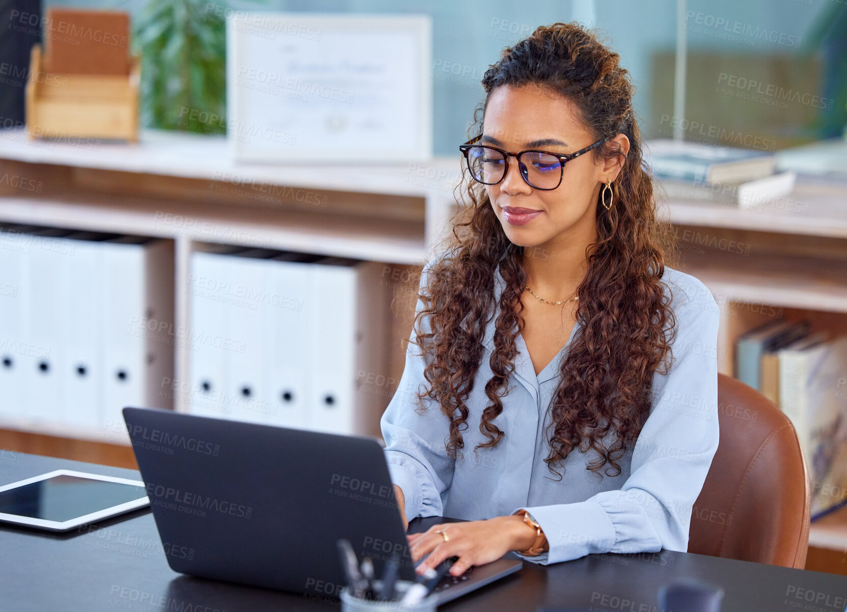 Buy stock photo Cropped shot of an attractive young businesswoman working on her laptop in the office