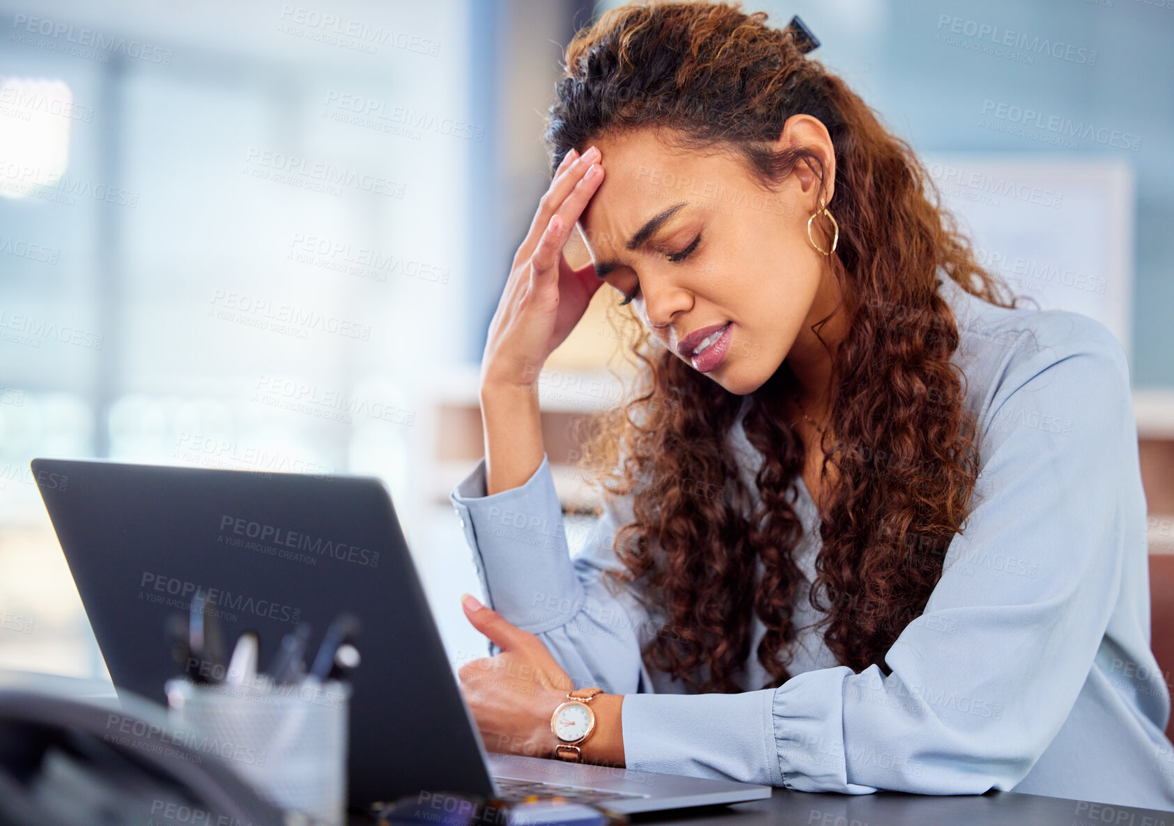 Buy stock photo Cropped shot of an attractive young businesswoman suffering with a headache while working on her laptop in the office