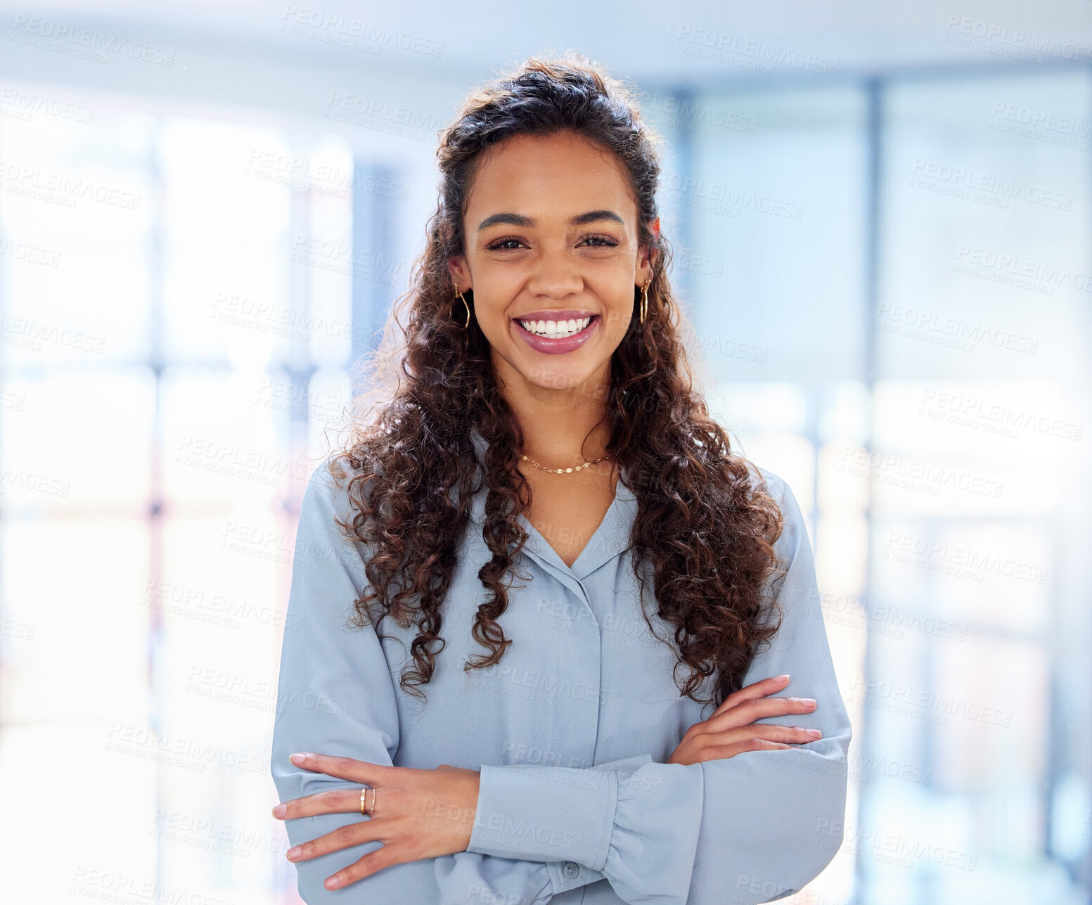 Buy stock photo Cropped portrait of an attractive young businesswoman standing with her arms folded in the office