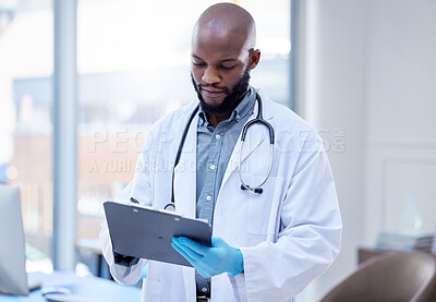 Buy stock photo Shot of a male doctor filling out paperwork