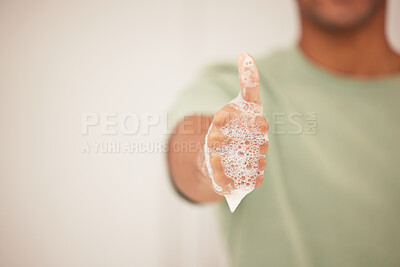 Buy stock photo Shot of a man giving the thumbs up with a soapy hand