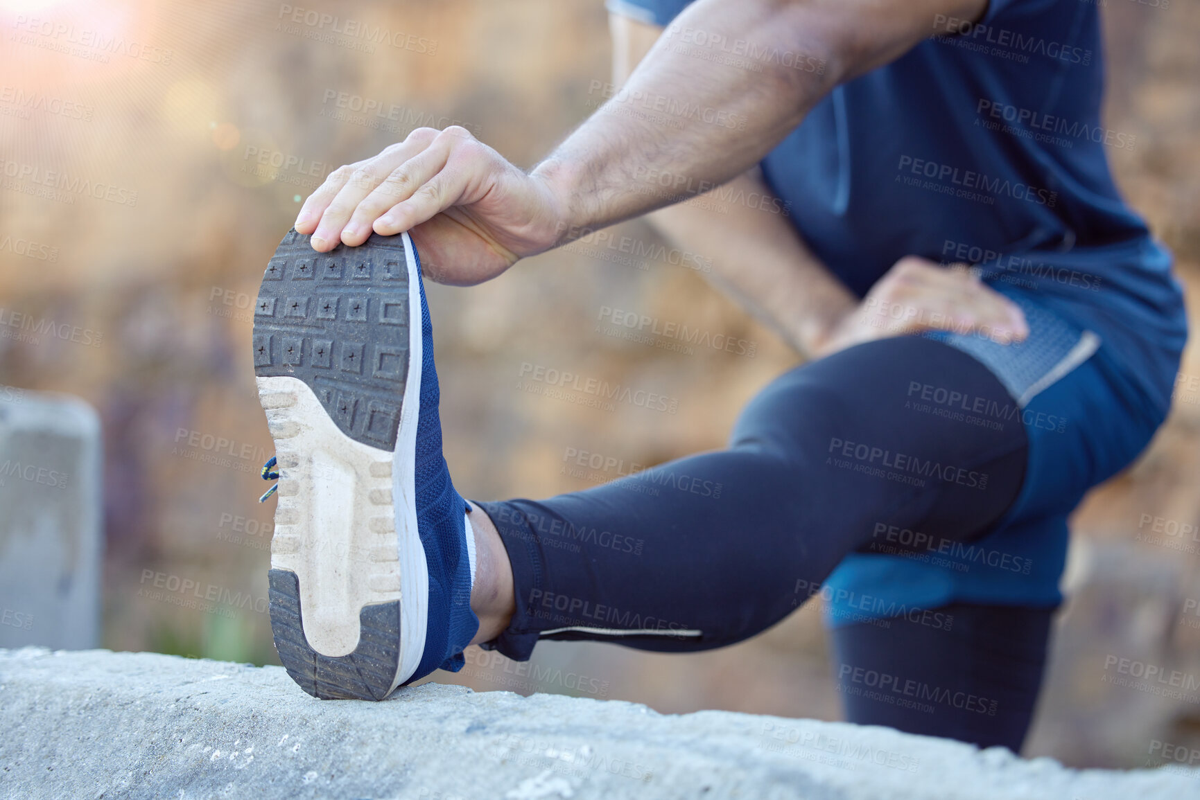 Buy stock photo Cropped shot of an unrecognisable man standing alone and stretching during his outdoor workout
