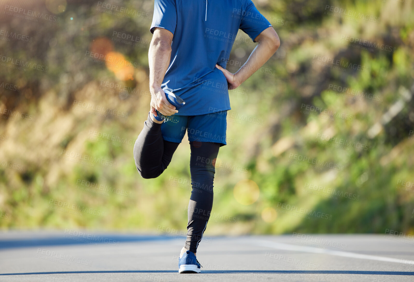 Buy stock photo Cropped shot of an unrecognisable man standing alone and stretching during his outdoor workout